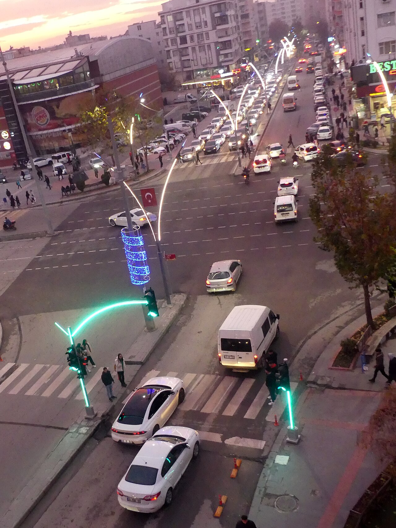 A busy city street intersection with traffic lights and signage.